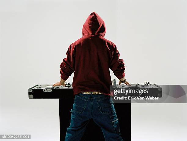 young male dj wearing hooded swat shirt, at mixing table, rear view, studio shot - dj table stock pictures, royalty-free photos & images