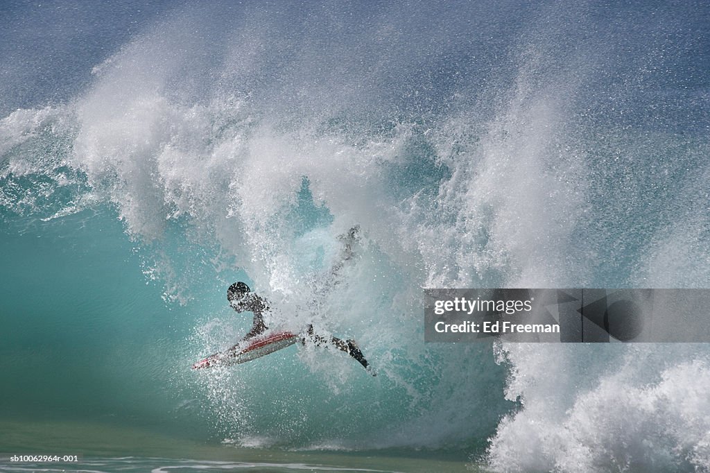 Man lying on surfboard in sea