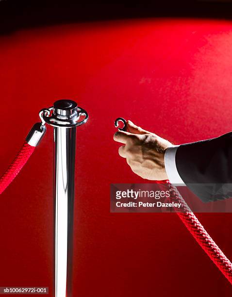 security man unclipping rope, close-up of hand - doorman stockfoto's en -beelden