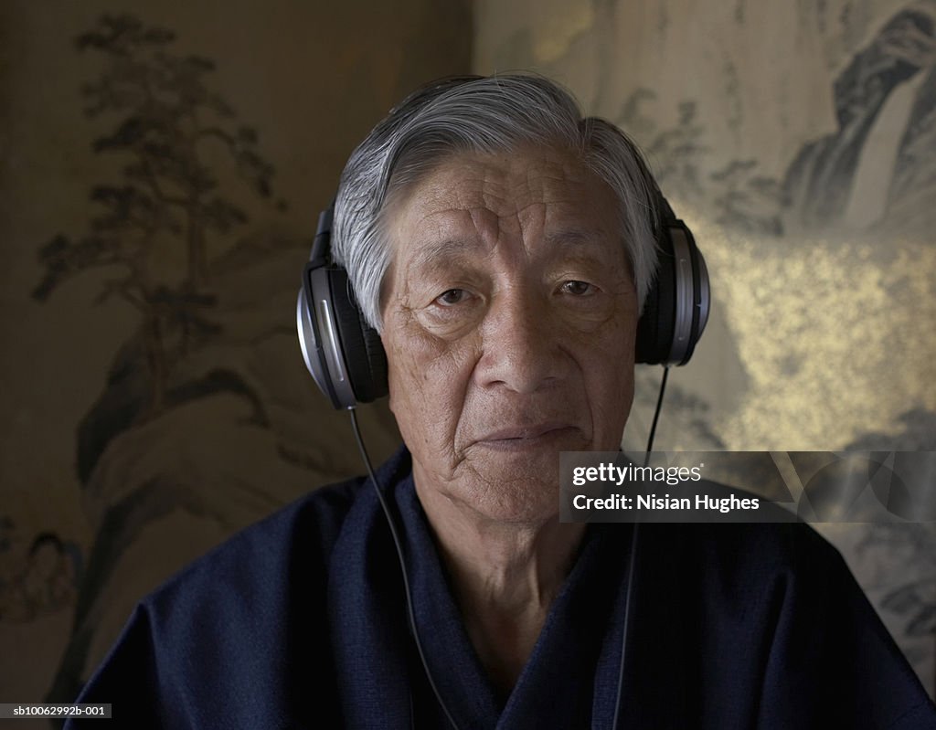 Senior man wearing headphones, portrait, close-up