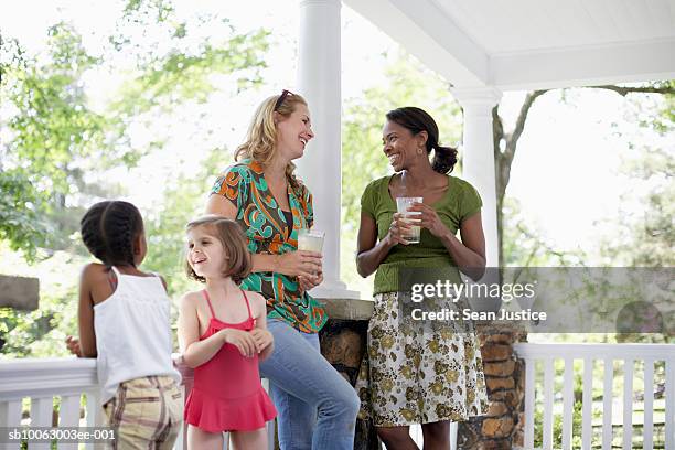 two women and girls (7-8 years) talking on porch - neighbour ストックフォトと画像