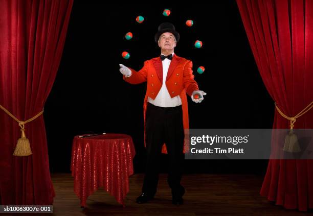 senior man juggling balls on stage - zauberer darstellender künstler stock-fotos und bilder