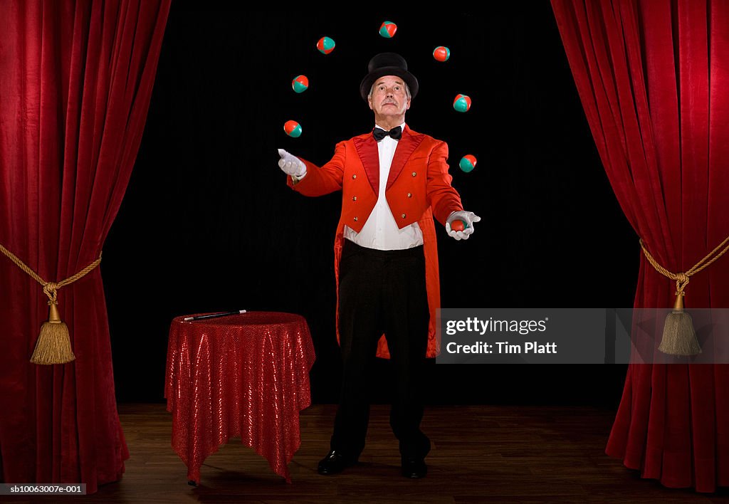 Senior man juggling balls on stage