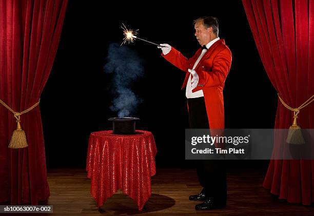 magician with smoke in hat on stage, side view - magia foto e immagini stock