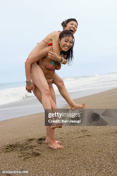 two young women messing about on beach, laughing - sandy messing stock pictures, royalty-free photos & images