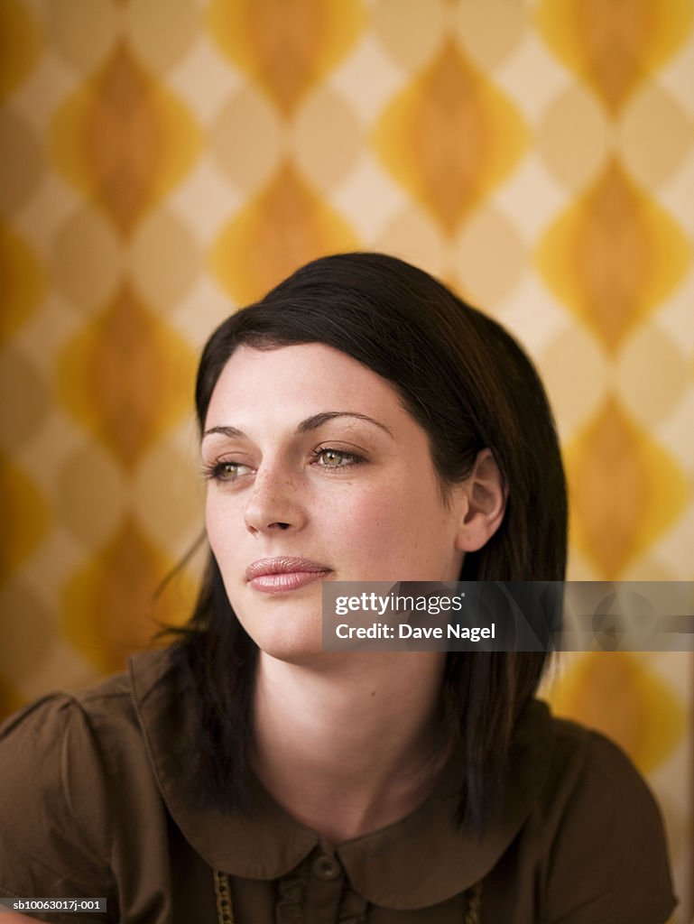 Young woman, looking away and smiling, head and shoulders