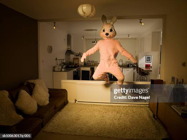 person in rabbit costume jumping in room - creepy house at night stock-fotos und bilder