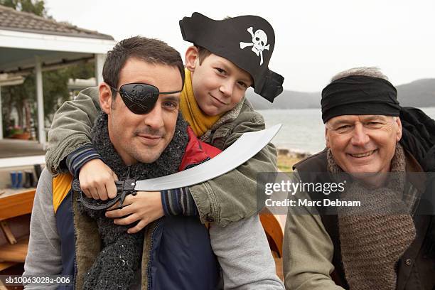 grandfather, father and grandson (10-11) wearing pirate costumes outdoors, portrait - holding sword stock pictures, royalty-free photos & images