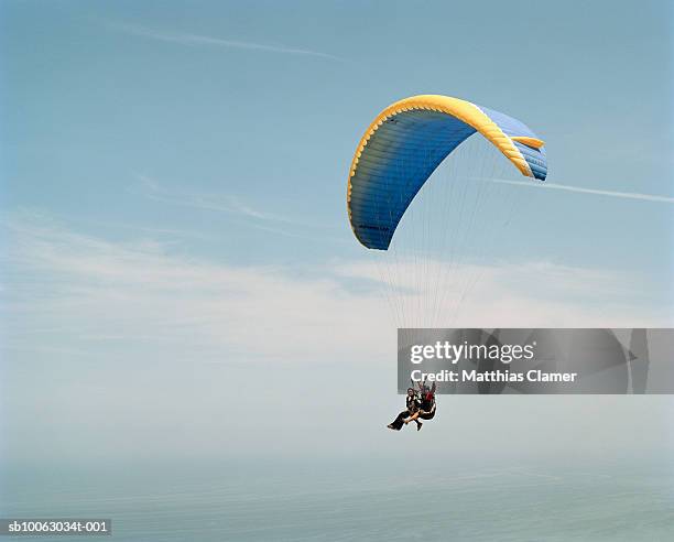 chile, san pedro de atacama, couple paragliding, low angle view - paragliding stock-fotos und bilder