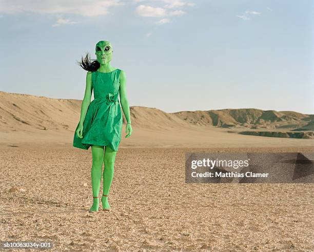 extraterrestrial wearing green dress standing in desert - extraterrestre photos et images de collection