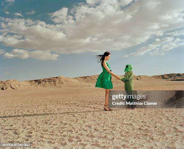 woman greeting extraterrestrial in desert landscape - antofagasta fotografías e imágenes de stock
