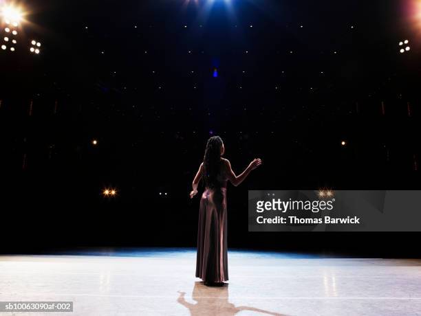female opera singer performing solo on stage, rear view - gesangskunst stock-fotos und bilder