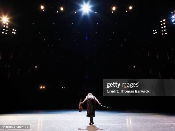 female violinist bowing on stage, rear view - geiger stock-fotos und bilder