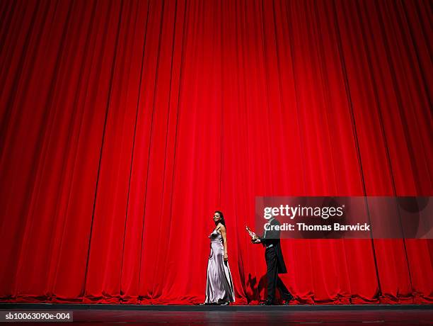male and female performer walking on stage holding award - drama awards stock pictures, royalty-free photos & images