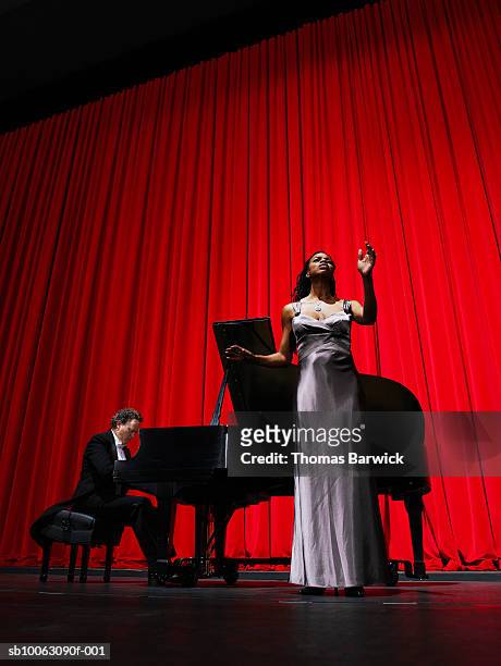 woman singing on stage accompanied by male pianist - pianista fotografías e imágenes de stock