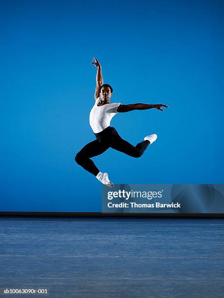 male ballet dancer leaping on stage - ballerinas stock-fotos und bilder