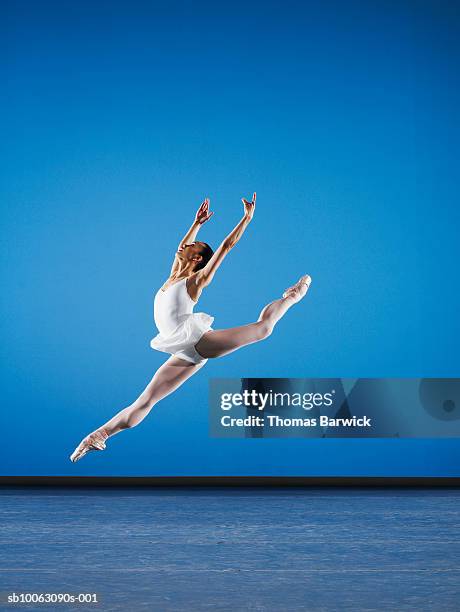 ballerina leaping on stage, side view - ballet dancer stock pictures, royalty-free photos & images