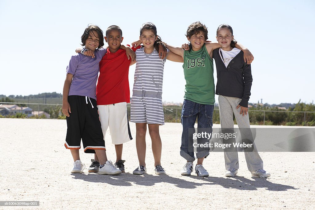 Group portrait of children (9-12) embracing outdoors