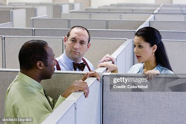 two men and woman talking in office cubicle - cubicle photos et images de collection