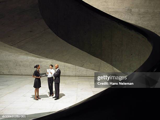 three business people talking indoors - relazione d'affari foto e immagini stock