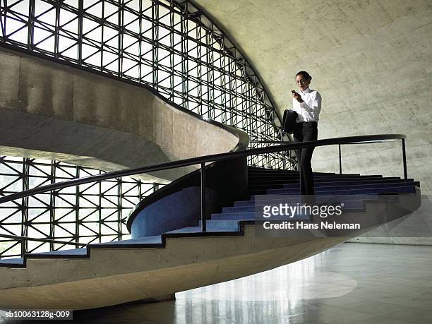 business woman walking down stairs in office, low angle view - mid distance stock pictures, royalty-free photos & images