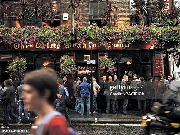 england, london, crowds in front of pub, pedestrian in foreground, blurred motion - british pub stock-fotos und bilder