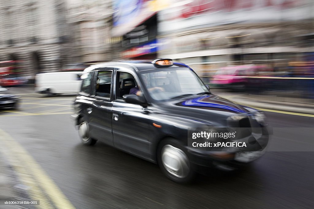 England, London, taxi on street, blurred motion