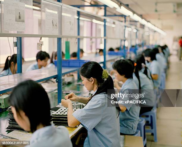 china, guangdong, uniformed workers at electronics factory - sweatshop stock-fotos und bilder