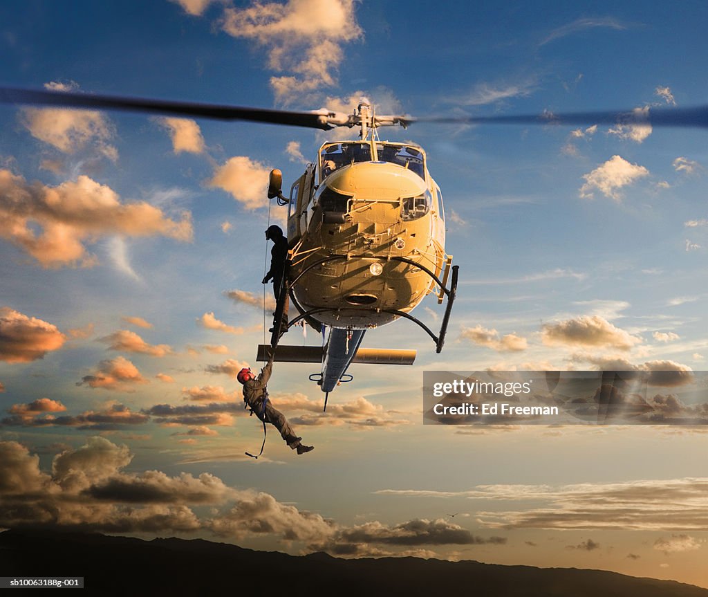 Man being pulled by rescue helicopter