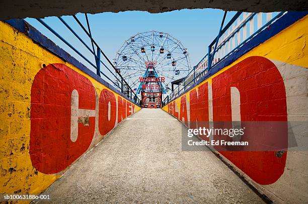 ferry wheel at amusement park with passageway in foreground - amusement park ride stockfoto's en -beelden