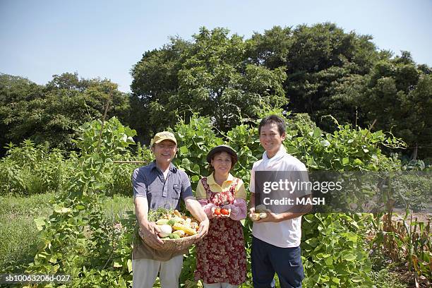 senior couple with son in field, smiling, portrait - 農作業 ストックフォトと画像