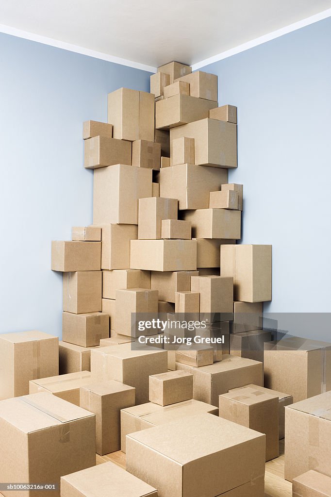 Cardboard boxes stacked in corner of room