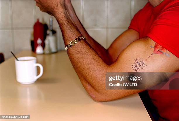 man with tattoo in cafe - bicep stock-fotos und bilder