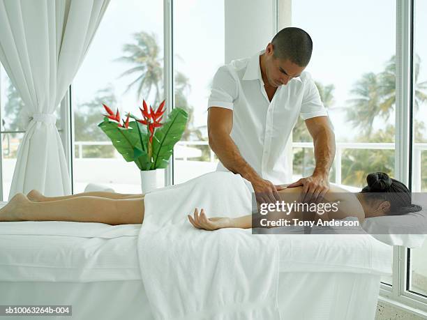 young woman receiving massage in spa - massage therapist woman stock pictures, royalty-free photos & images