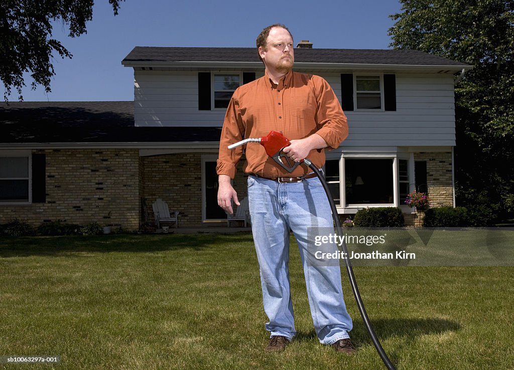 Man holding fuel pump in lawn