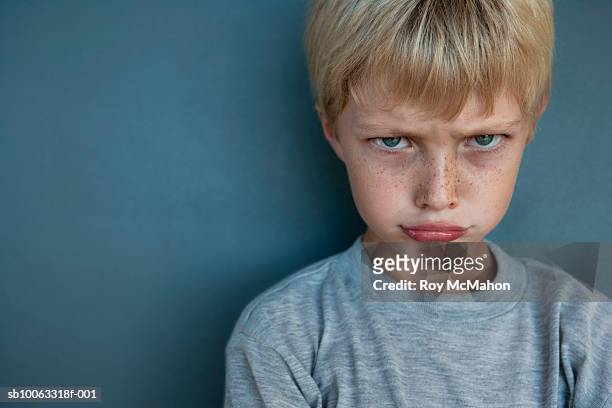 boy (8-9 years) making face, studio shot, portrait - 8 9 years stock pictures, royalty-free photos & images