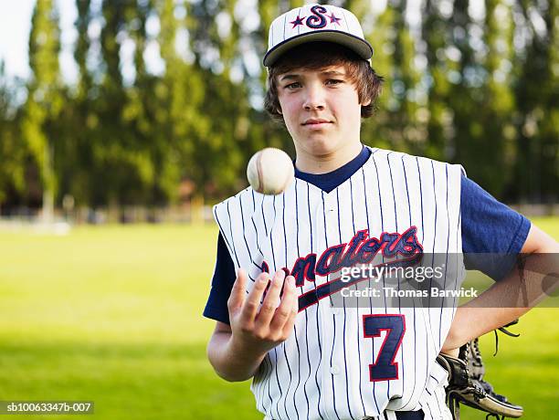 teenage boy (13-14) baseball player tossing ball in hand, portrait - boy throwing stockfoto's en -beelden