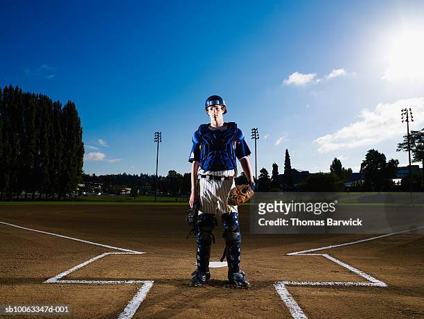 teenage boy (13-14) baseball catcher at home plate, portrait - baseballfänger stock-fotos und bilder
