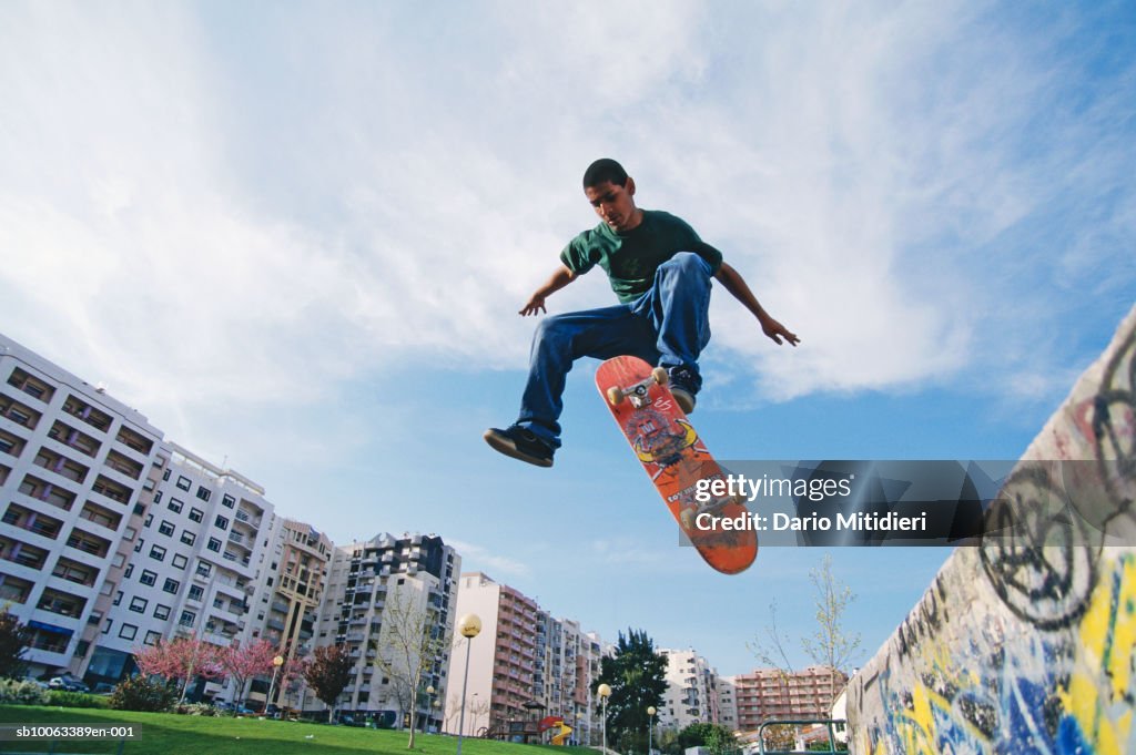 Teenage boy (16-17) practicing skateboard trick, low angle view