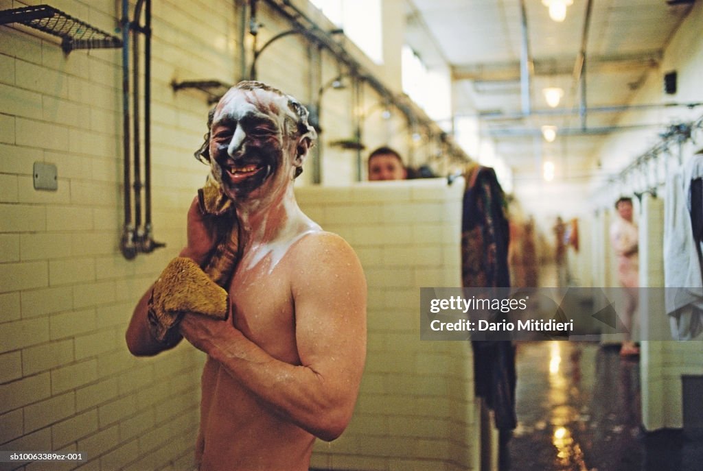 Miners showering after shift, man in foreground looking at camera