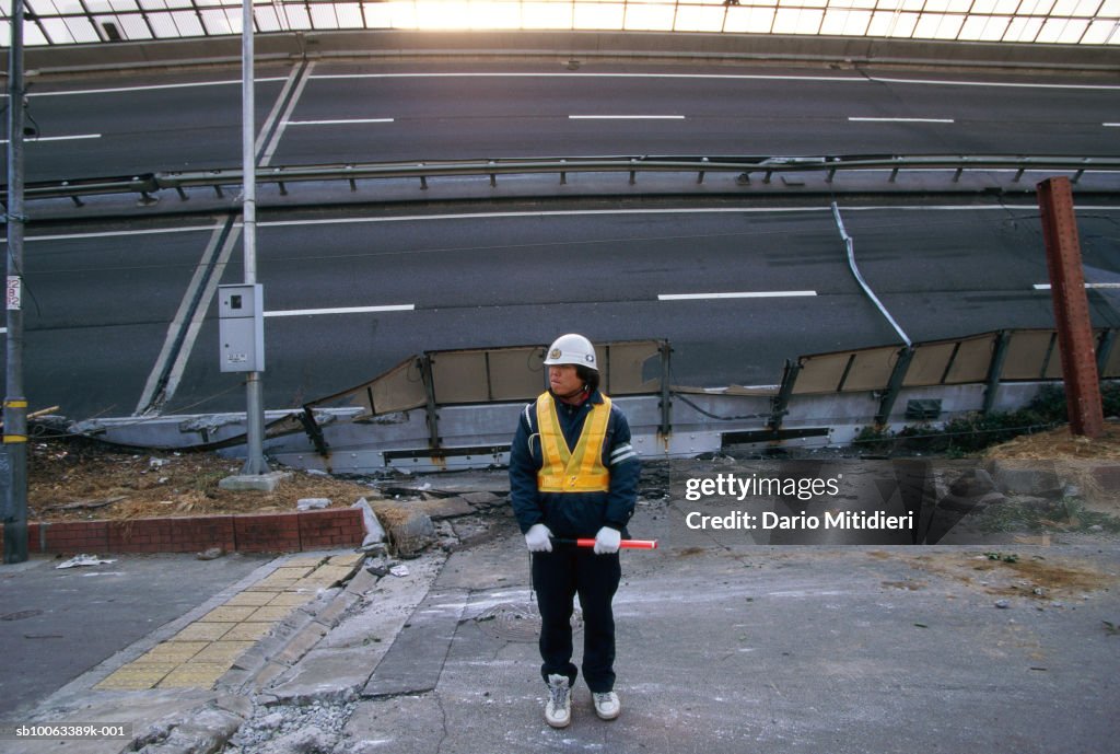 Japan, Osaka, Kobe, emergency services worker by road destroyed in earthquake
