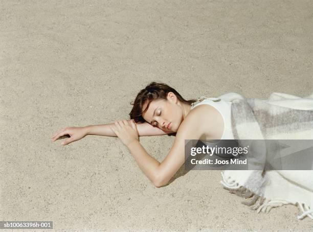 young woman lying on beach, eyes closed, elevated view - ligga på mage bildbanksfoton och bilder