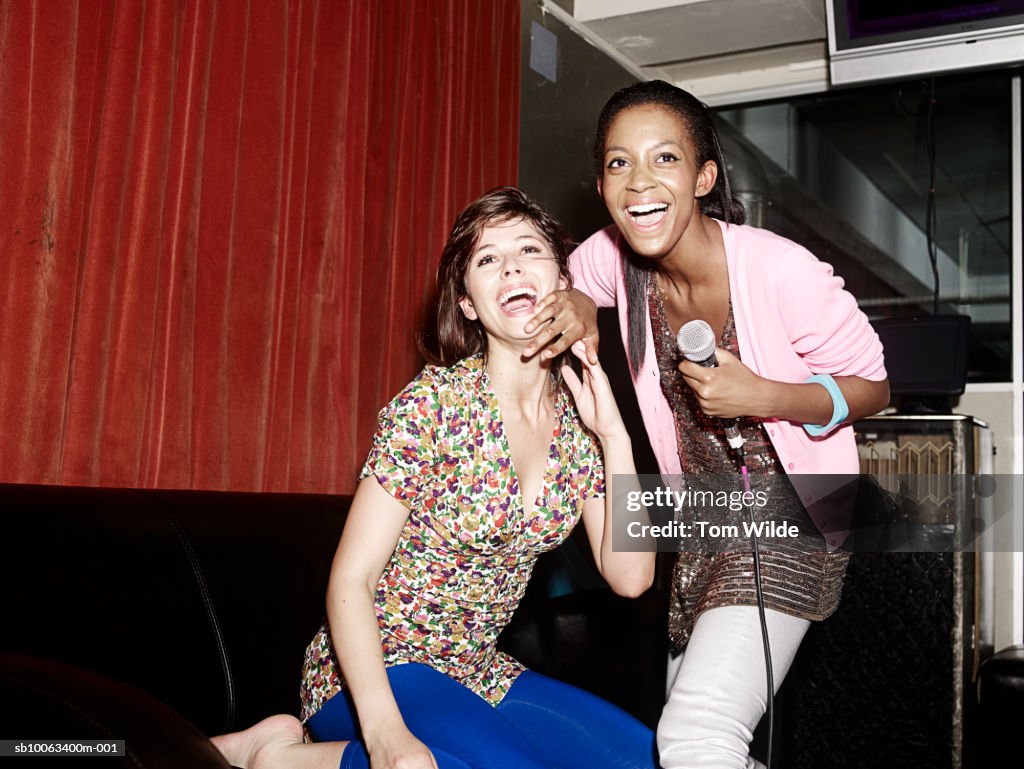 Two friends singing in karaoke booth