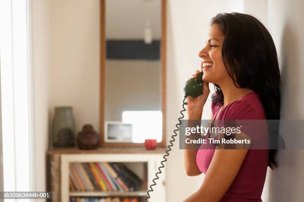 woman using telephone in hallway - teléfono con cable fotografías e imágenes de stock