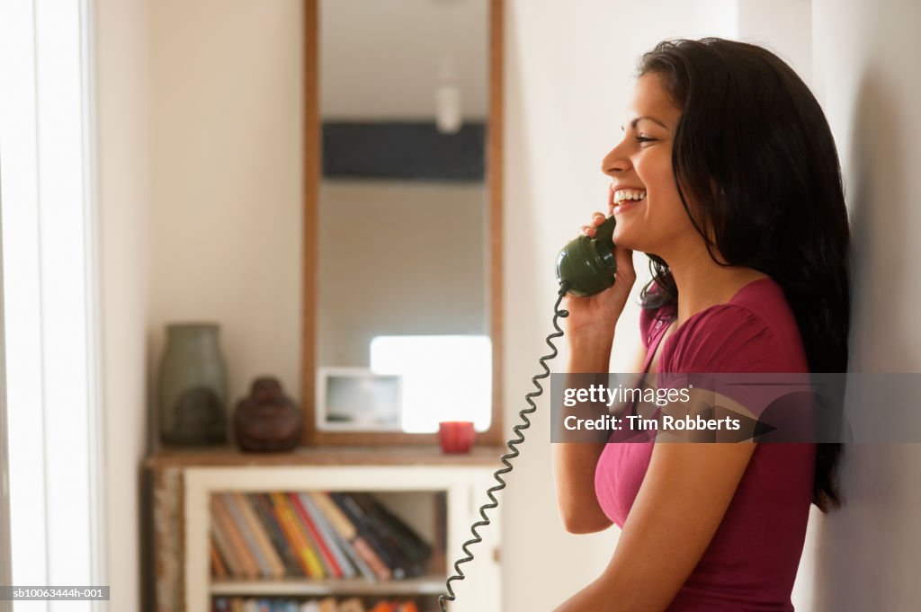 Woman using telephone in hallway