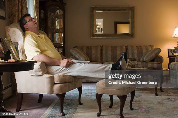 mature man sleeping in armchair in living room, side view - michael sit stock pictures, royalty-free photos & images