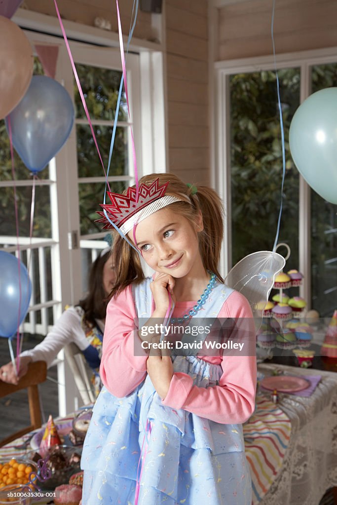 Girl (6-7) at birthday party, holding balloon, smiling