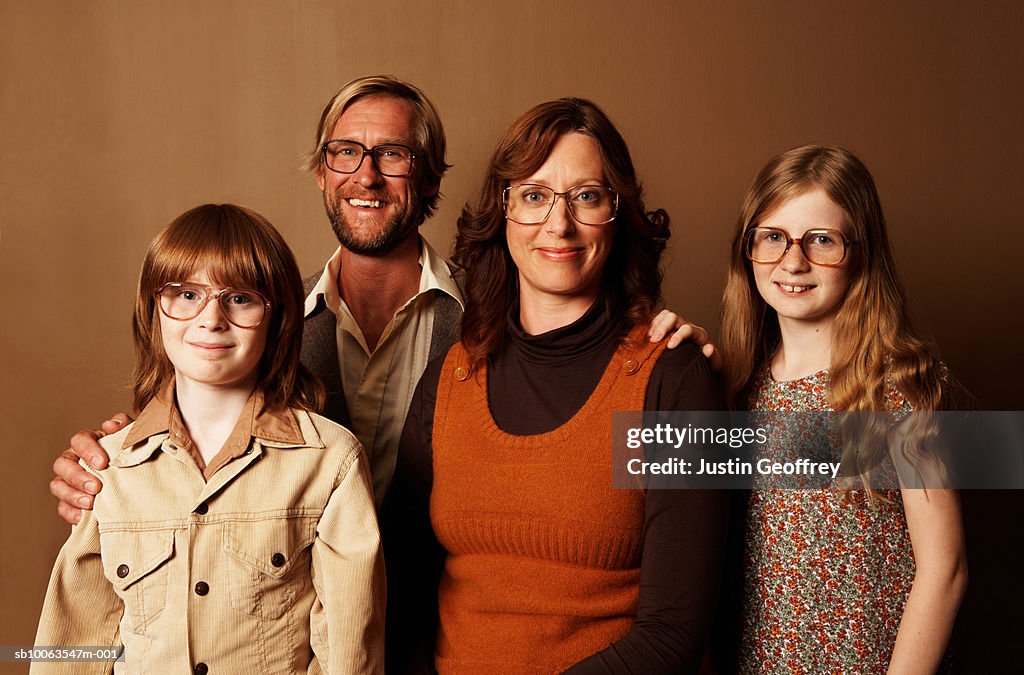 Parents and two children (9-11) wearing spectacles, smiling, portrait