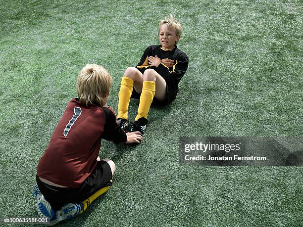 boys (9-10 years) doing sit ups on soccer field, elevated view - 10 11 years boy stockfoto's en -beelden