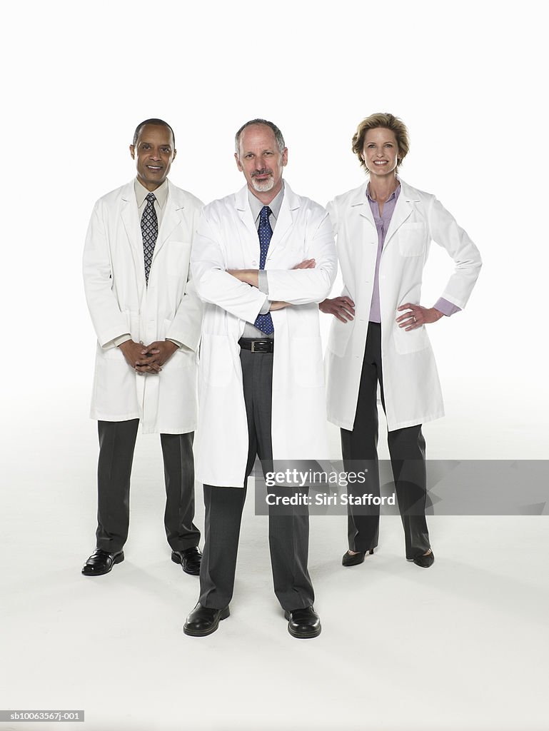 Three doctors standing on white background, portrait